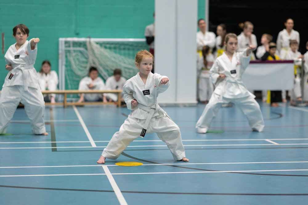 A young girl performing a front stance with a focused punch during the TAGB Tae Kwon Do colour belt grading at Hereford Halo Leisure Centre